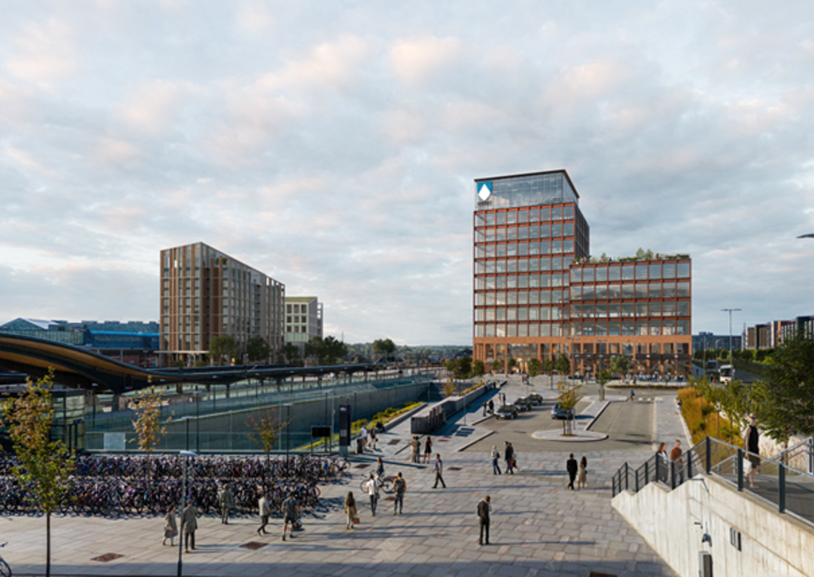 Illustrasjon av stort fylkeshus til høyre for en stasjon. Stort torg foran.