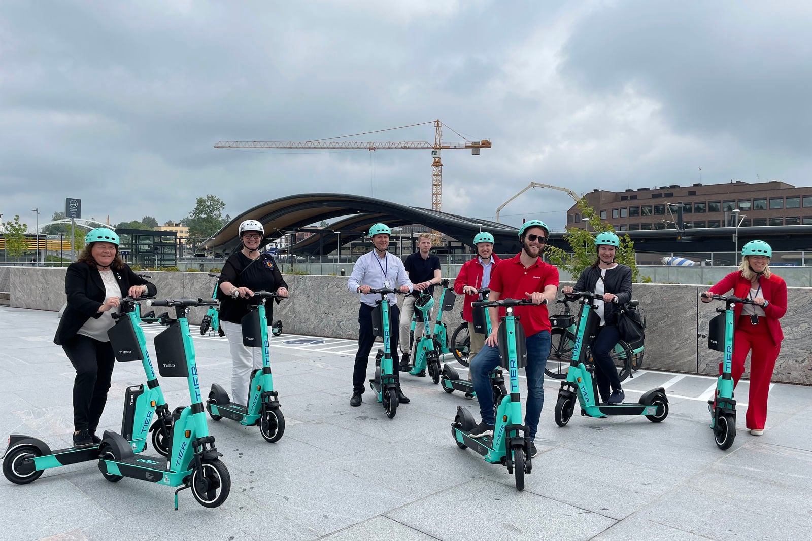 Mennesker med hver sin el-sparkesykkel foran Ski stasjon.